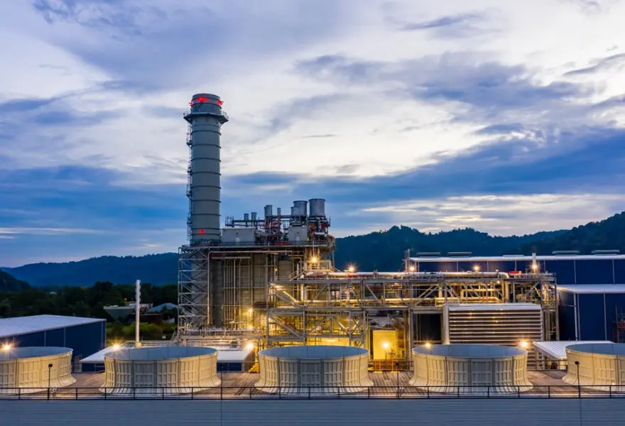 Power plant operations – looking west across cooling tower to HRSG, pipe rack, and turbine building